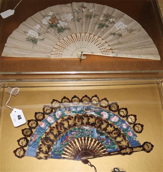 Two Chinese export fans, 19th century, the first a gilt decorated lacquer cabriolet fan, c.1860, length 30cm, both in perspex cases